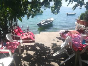 a boat in the water with chairs and a table at Villa Dudanov in Ohrid