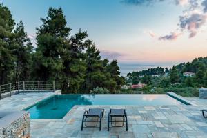 a swimming pool with two chairs and a view at Elios Private Living in Neo Klima