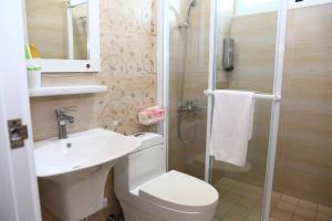 a bathroom with a toilet and a sink and a shower at 500Km Home in Hualien City +28 photos