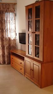 ein großer Holzschrank mit einem TV in einem Zimmer in der Unterkunft Primera linea del mar in Punta del Hidalgo