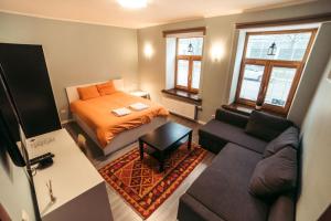 a small room with a bed and a couch at 40 Saules in Ventspils
