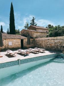 a swimming pool with lounge chairs and umbrellas at Domaine de Carraire in Aix-en-Provence