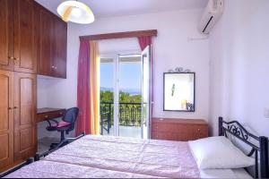 een slaapkamer met een bed, een bureau en een raam bij Marina's House in Gaios