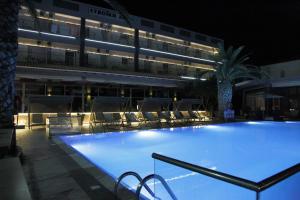 a large swimming pool in front of a building at night at Evvoiki Akti Hotel in Politika