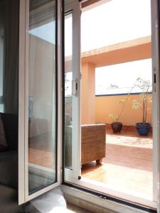 バレンシアにあるAtico Duplex Luminosoのパティオを望むガラスのスライドドア