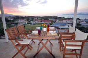 uma mesa e cadeiras numa varanda com vista em Corinthian Sun - Vacation Home em Corinto