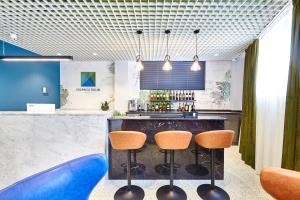 a bar with orange chairs and a blue counter at Graphica Tbilisi Hotel in Tbilisi City