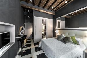 ein Schlafzimmer mit einem Bett und einem TV in der Unterkunft Piazza di Spagna Luxury Apartment in Rom