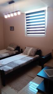 sala de estar con 2 camas y ventana en Asterix Rooms en Leskovac