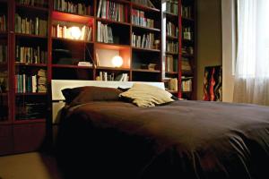 um quarto com uma cama e estantes de livros com livros em I Mulini B&B em Vigevano