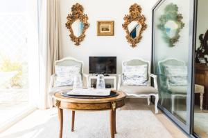 a living room with a table and two chairs and mirrors at Entre Mar e Mar in Aldeia do Meco