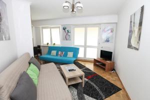 salon z kanapą i stołem w obiekcie Green Kabaty Apartment 1 w Warszawie