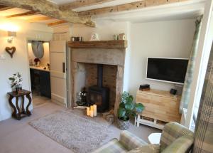 a living room with a fireplace and a tv at No 2 in Kirkby Lonsdale