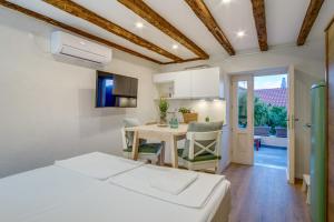 a bedroom with a bed and a table and a kitchen at Casa Rustica in Mali Lošinj