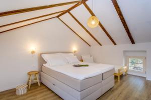 a bedroom with a large white bed in a attic at Casa Rustica in Mali Lošinj