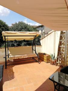 un patio con un letto sotto un grande ombrellone di Soggiorno Arcobaleno a Firenze