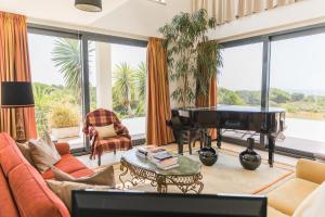 a living room with a piano and a couch at Entre Mar e Mar in Aldeia do Meco