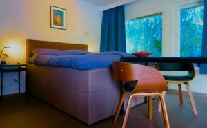 a bedroom with a bed and a table and a chair at B&B De Leeuw in Zwolle +54 photos