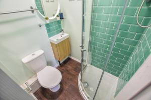 a bathroom with a toilet and a sink and a shower at Regency GuestHouse Manchester North in Manchester