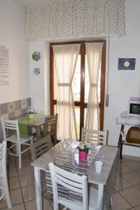 ein Esszimmer mit Tischen, Stühlen und einem Fenster in der Unterkunft Mary's house in Neapel