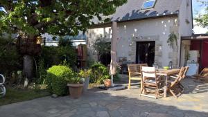 eine Terrasse mit Tisch und Stühlen in einem Hof in der Unterkunft LA MAISON DE BIORD in Saint-Jacut-de-la-Mer
