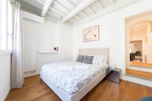 a white bedroom with a bed and a window at San Niccolò hidden gem suite in Florence