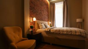a bedroom with a bed and a brick wall at UNIRII OLD SQUARE APARTMENTS 4 in Timişoara