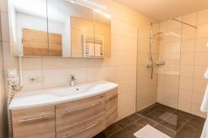een badkamer met wastafel en douche bij Appartment Hotel Mitterer in Saalbach Hinterglemm +59 foto's