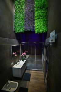 bagno con lavandino e doccia con piante verdi di Moscova Attic Near Duomo a Milano