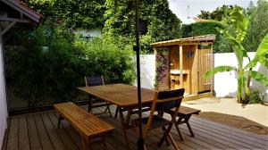 a wooden table and chairs on a wooden deck at Ravissante maison 300 Mètres de la plage in Notre-Dame-de-Monts
