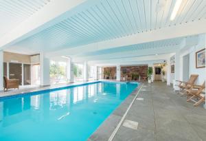a swimming pool with blue water and a white ceiling at Northfield Hotel in Minehead