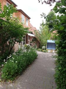 a brick walkway in front of a house at Hotel Garni Friesenhuus in Greetsiel