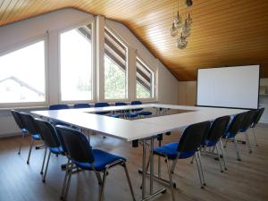 una sala de conferencias con una mesa grande y sillas en Haus Vita Ferien- und Seminarhaus, en Urberg