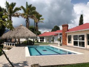 a swimming pool in front of a house at El Bongo de Chinauta in Fusagasuga