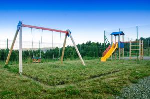 an empty playground with a slide in a field at Camp The sunrise hill in Pivka