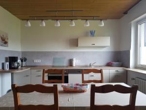 a kitchen with a table and some chairs and a table at Nelkenweg in Homburg