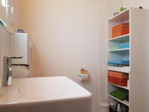 a bathroom with a sink and a shelf with towels at Nelkenweg in Homburg