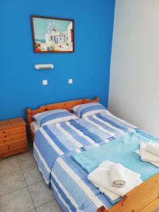 ein blaues Schlafzimmer mit einem Bett mit Handtüchern darauf in der Unterkunft Vangelis Studios in Skala Potamias