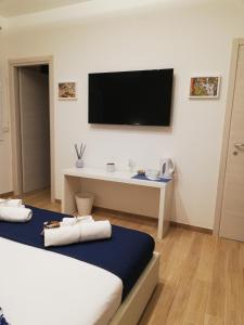 a room with two beds and a television on the wall at Sicitaly taormina in Taormina