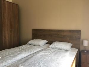 1 dormitorio con 1 cama con 2 almohadas en Konrad Apartman en Balatonmáriafürdő