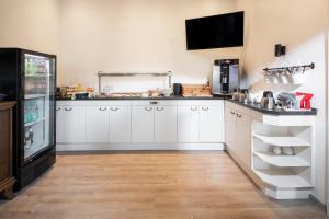 a kitchen with white cabinets and a refrigerator at Haus Neunaber in Norderney