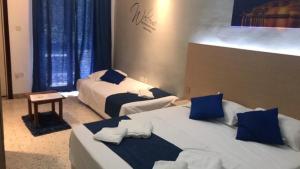 2 łóżka w pokoju hotelowym z niebieskimi poduszkami w obiekcie Le Malte House St. Julians w mieście St. Julian’s