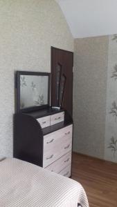 a bedroom with a dresser with a mirror and a bed at Natali & Giga in Ureki