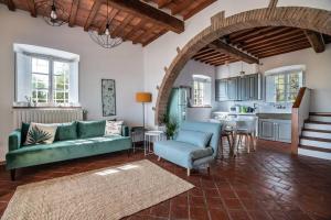 a living room with a green couch and a kitchen at Appartamento con magnifica vista e piscina in Lucca