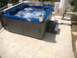 een hot tub met een blauwe top op een patio bij Apartmani Ivan V RELAX in Vodice
