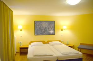 a bedroom with two beds and a painting on the wall at Hotel Villa Kisseleff in Bad Homburg vor der Höhe