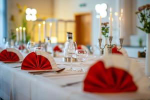 einen Tisch mit roten Servietten und Weingläsern darauf in der Unterkunft Landhotel Zum Niestetal in Kassel
