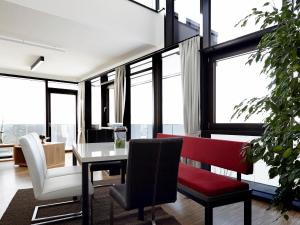 a living room with a table and chairs and windows at Thurnbach - Top Level Apartments in Aschau