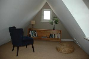 コルマールにあるappartement à Colmarの椅子、本棚、窓が備わる客室です。