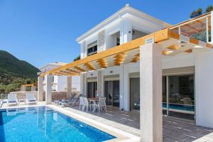 een villa met een zwembad en een huis bij VILLA NONA in Sivota